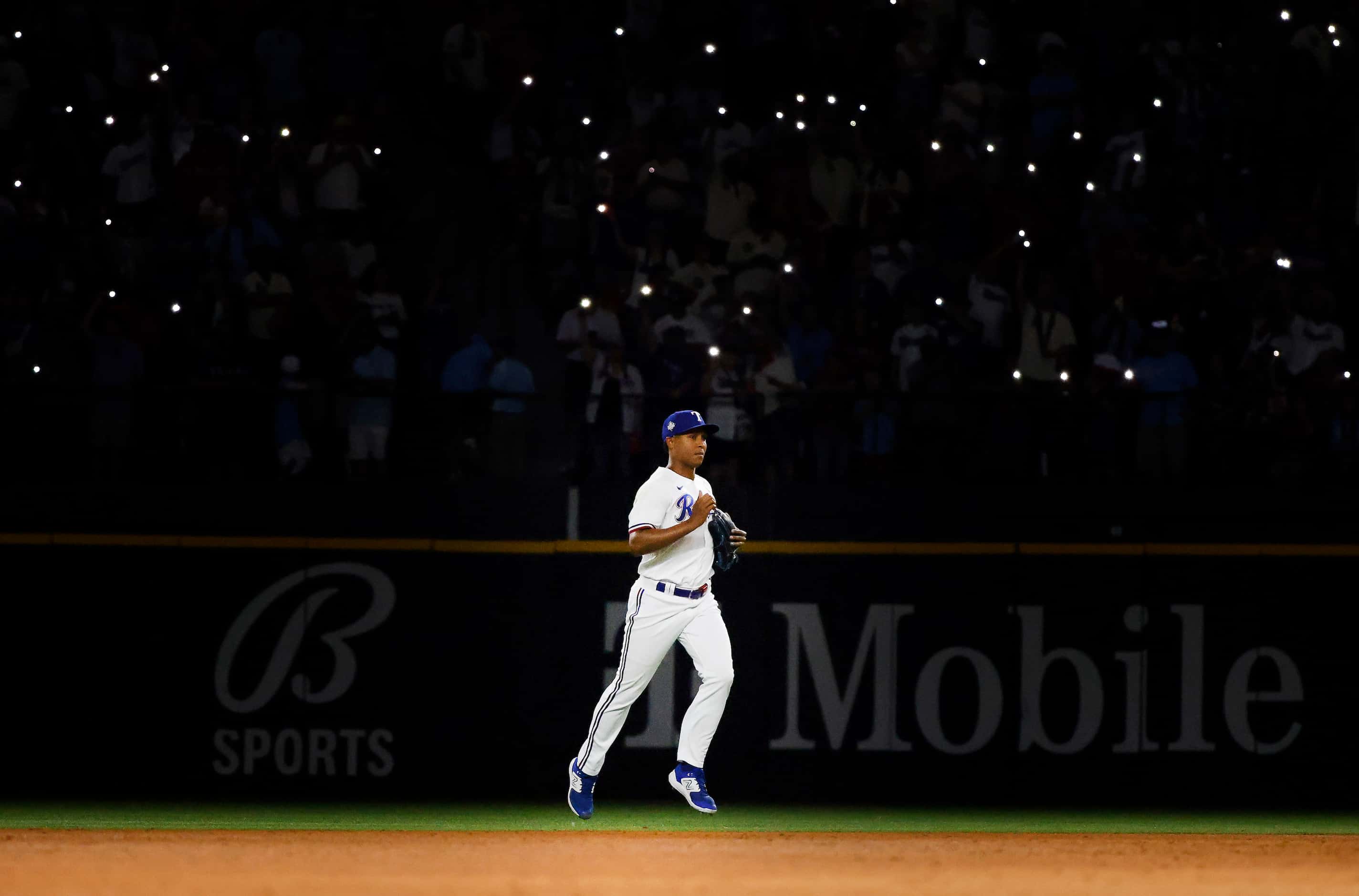 With the lights dimmed and smartphone lights on, Texas Rangers relief pitcher Jose Leclerc...