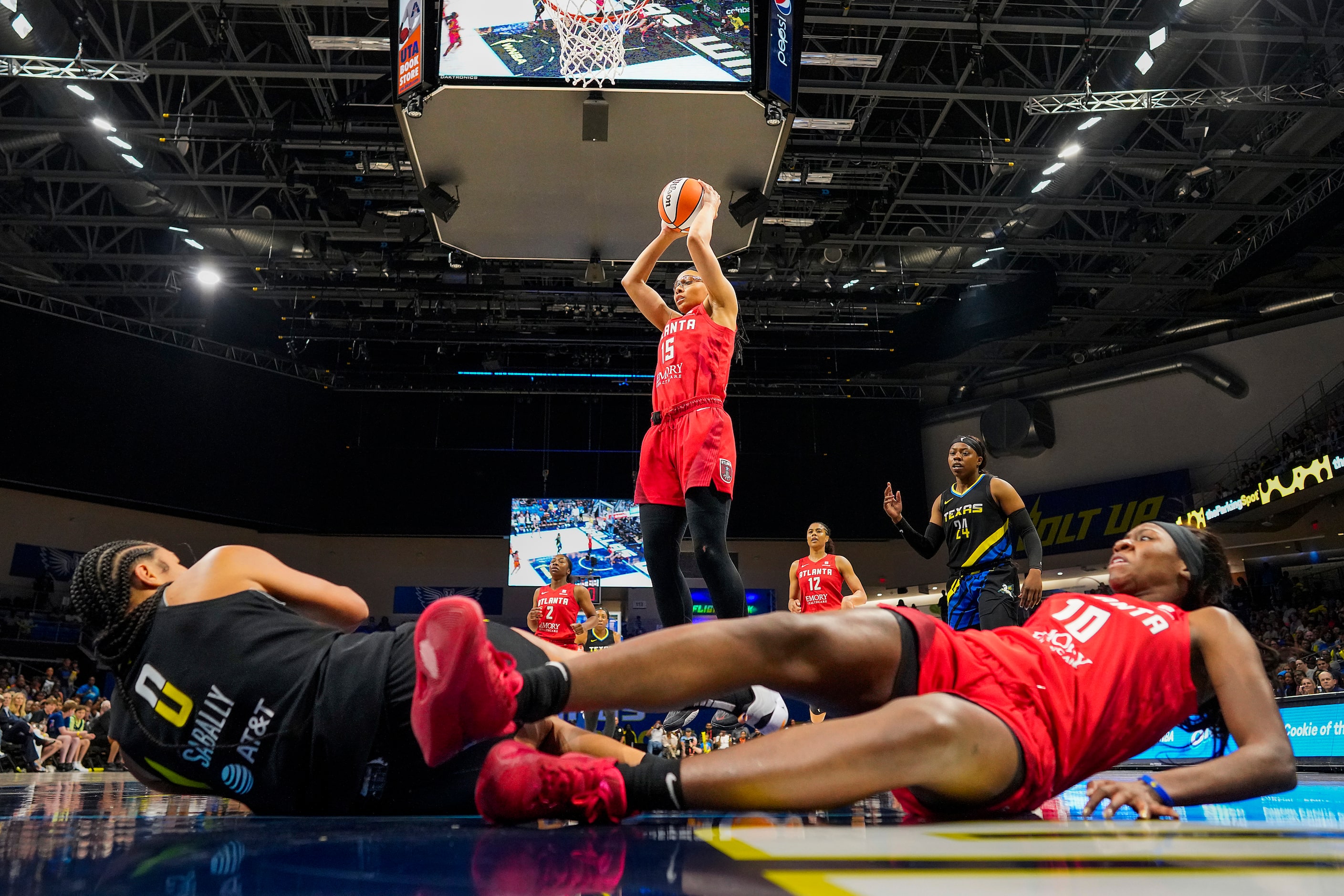 Dallas Wings forward Satou Sabally (0) and Atlanta Dream guard Rhyne Howard (10) tumble to...