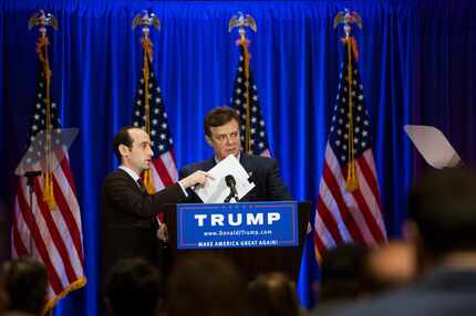 Stephen Miller, left, a campaign aide, covers the microphone while Donald Trump's campaign...