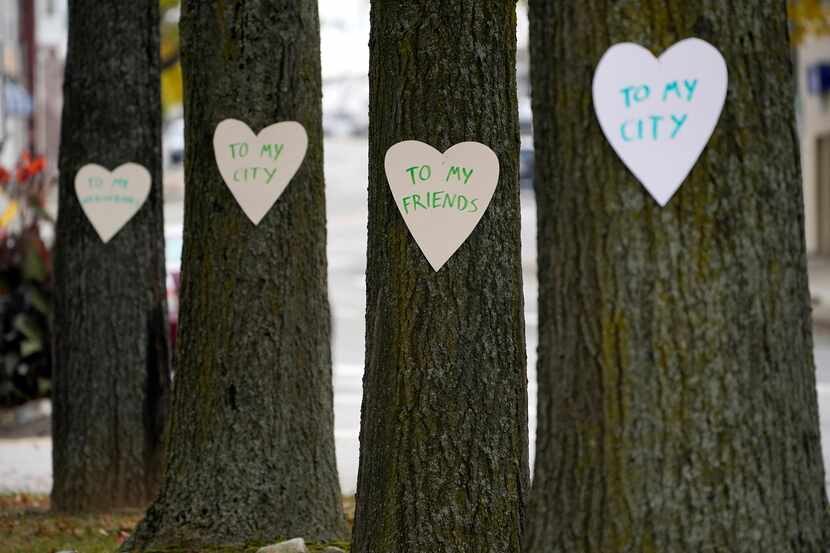 Heart-shaped cut-outs with messages of positivity adorn trees in downtown Lewiston, Maine,...
