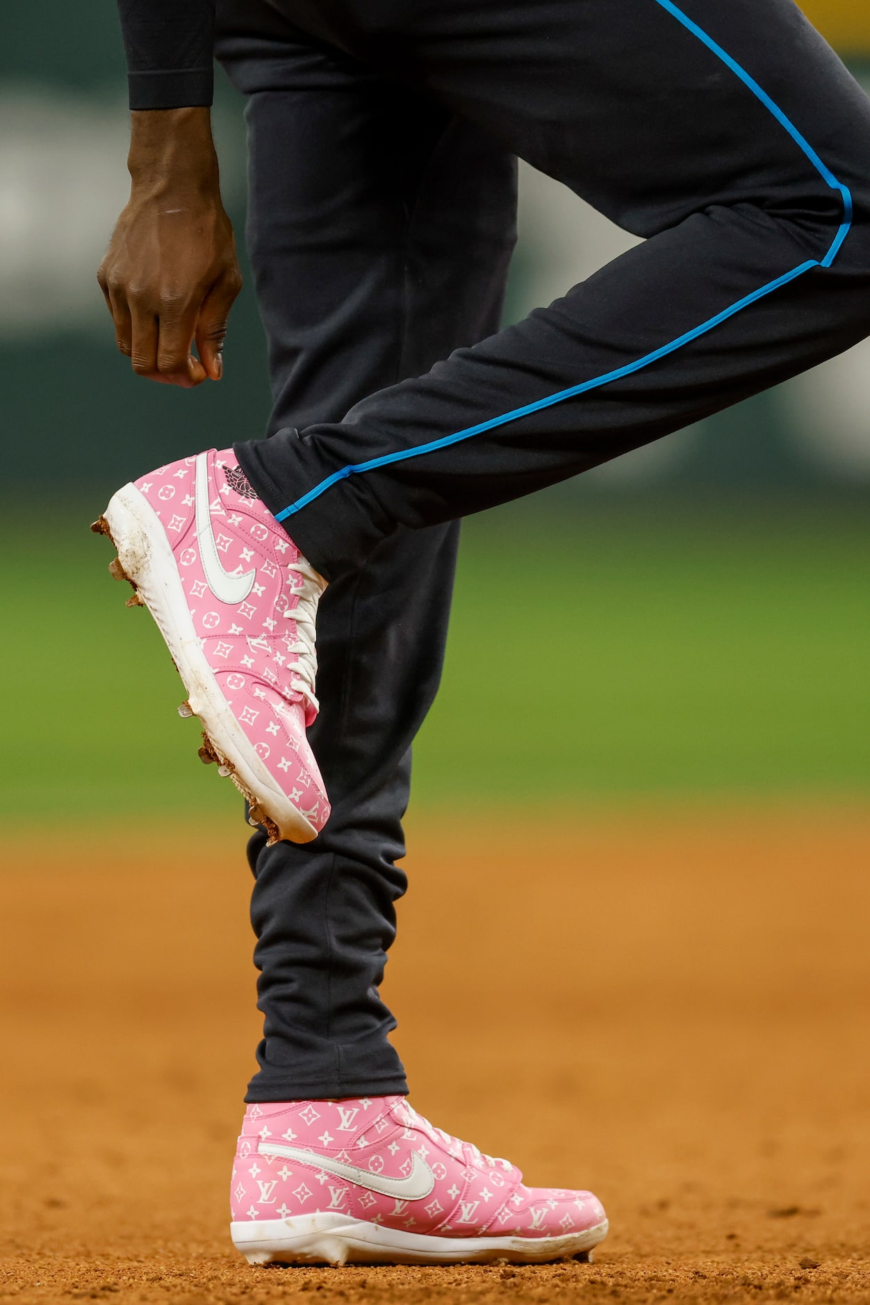 National League's Elly De La Cruz, of the Cincinnati Reds, adjusts his pants as he wears...