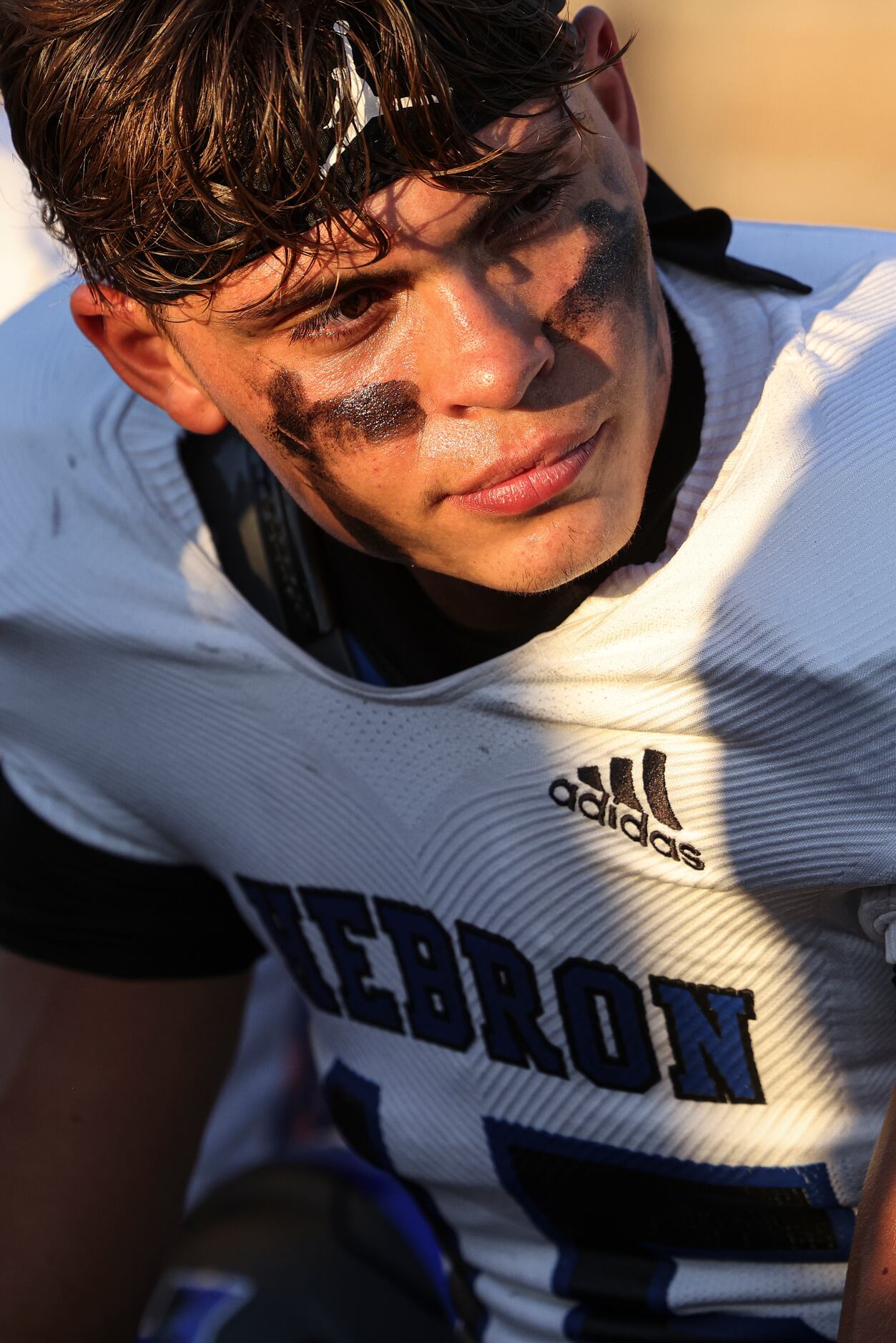 Hebron High School quarterback Braxton Baker (15) sits on the bench during the football game...