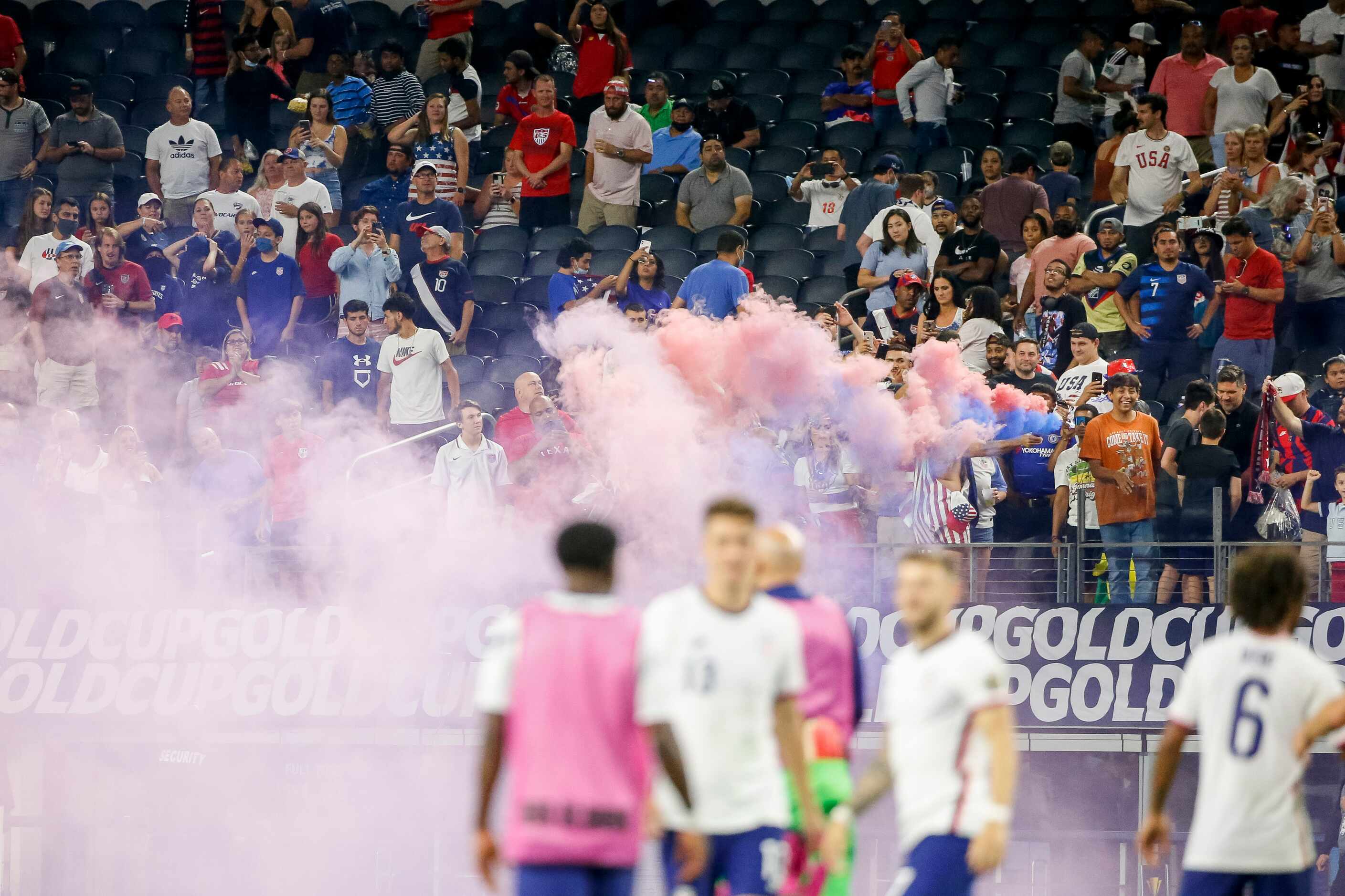 A smoke bomb fills the air after a CONCACAF Gold Cup quarterfinal soccer match between USA...