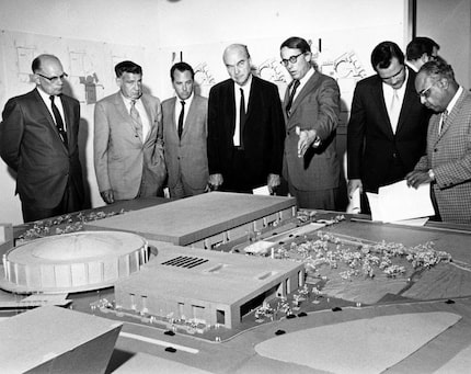 Dallas Mayor J. Erik Jonsson (center, black suit) and architect E. G. Hamilton (gesturing)...