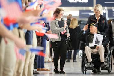 D-Day veteran Seymour Tipper salutes as he is greeted at Charles de Gaulle airport,...