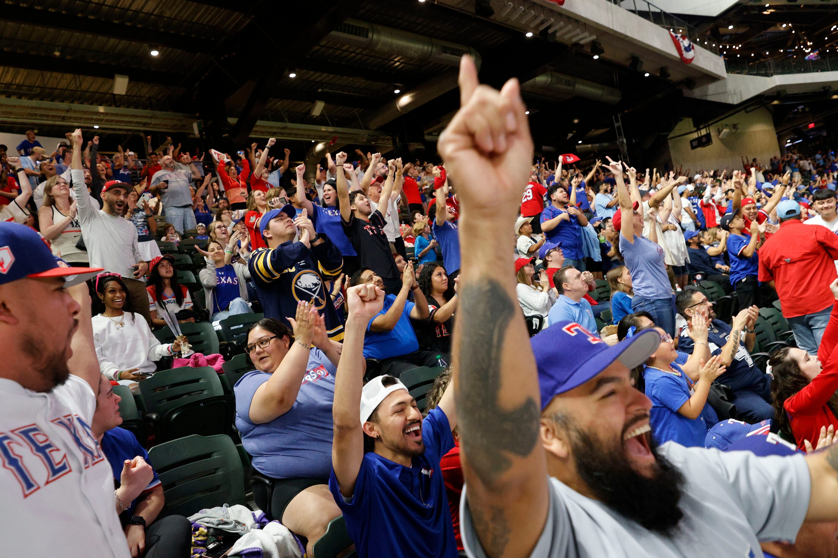 Texas Rangers fan John Sanchez of Cedar Hill, right, reacts during a Game 7 watch party of...