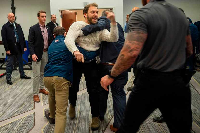 A protester is dragged from the room as Donald Trump Jr. speaks  during a "Keep Iowa Great"...
