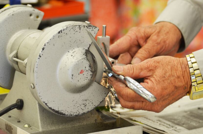 Katsumoto (75) of Grand Prairie puts a pair of Fiskars on the grinder, creating a small...