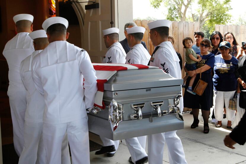 A U.S. Navy honor guard carries the body of Gunner's Mate 2nd Class Noe Hernandez into the...