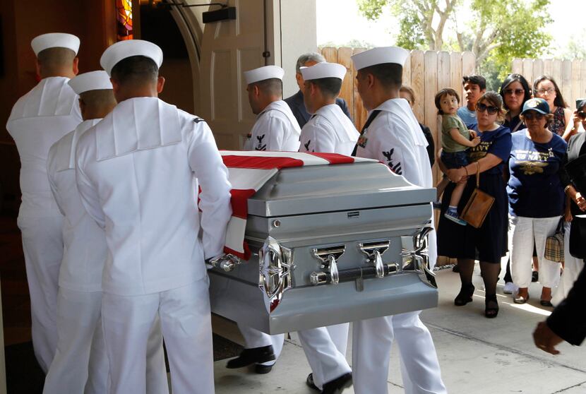 A U.S. Navy honor guard carries the body of Gunner's Mate 2nd Class Noe Hernandez into the...