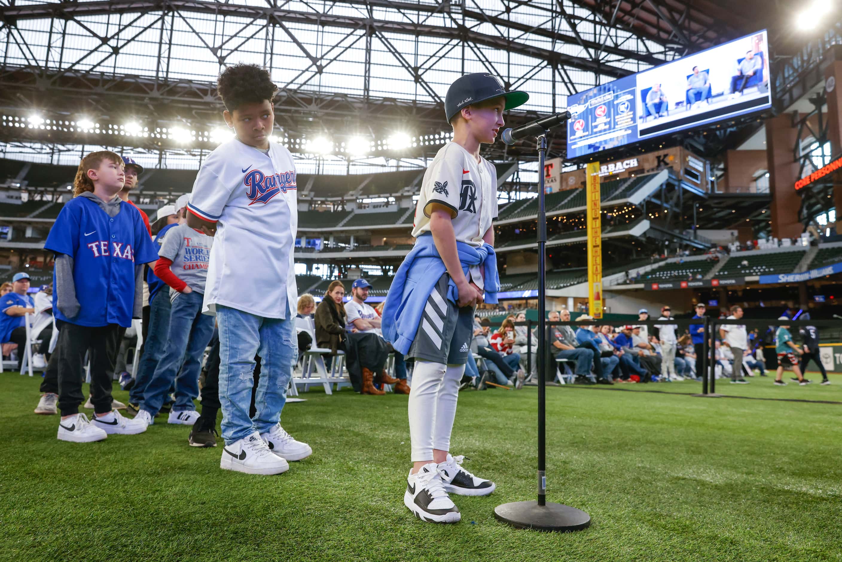 Bo Baldwin, 8, (front), asks a question to Texas Rangers’ pitchers Nathan Eovaldi and dane...