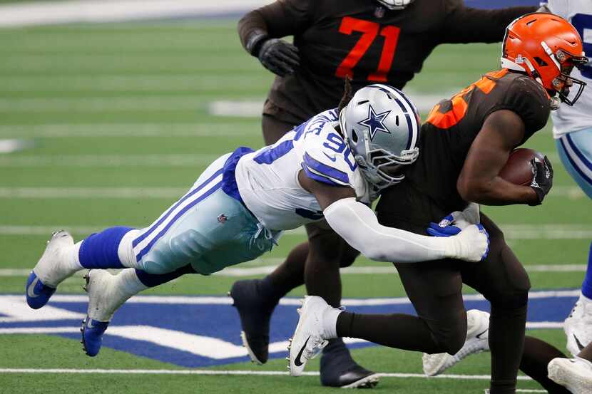 El ala defensiva de los Dallas Cowboys, DeMarcus Lawrence, captura al corredor de los...
