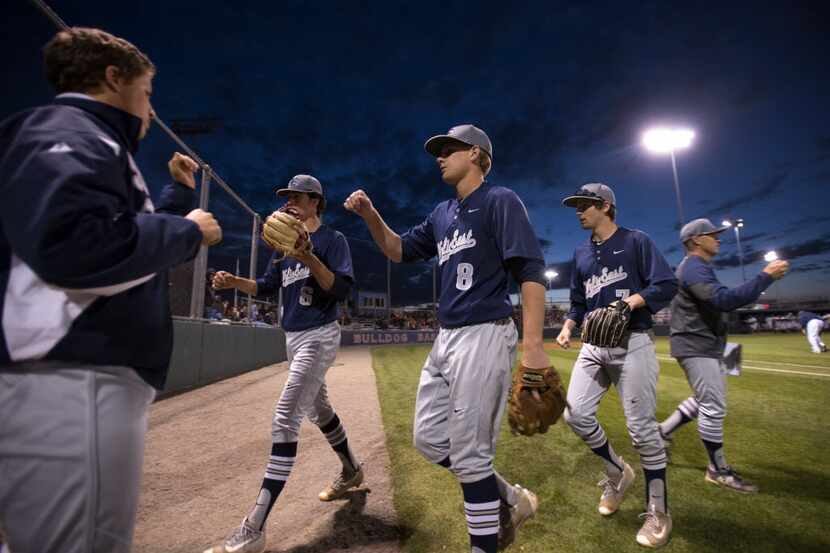 Wylie East shortstop Dalton Burt (8) gets a first bump from Cooper Andrews as he leaves the...