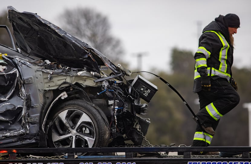 A crumbled car was towed as emergency crews worked to clear the crash on Interstate 35W in...
