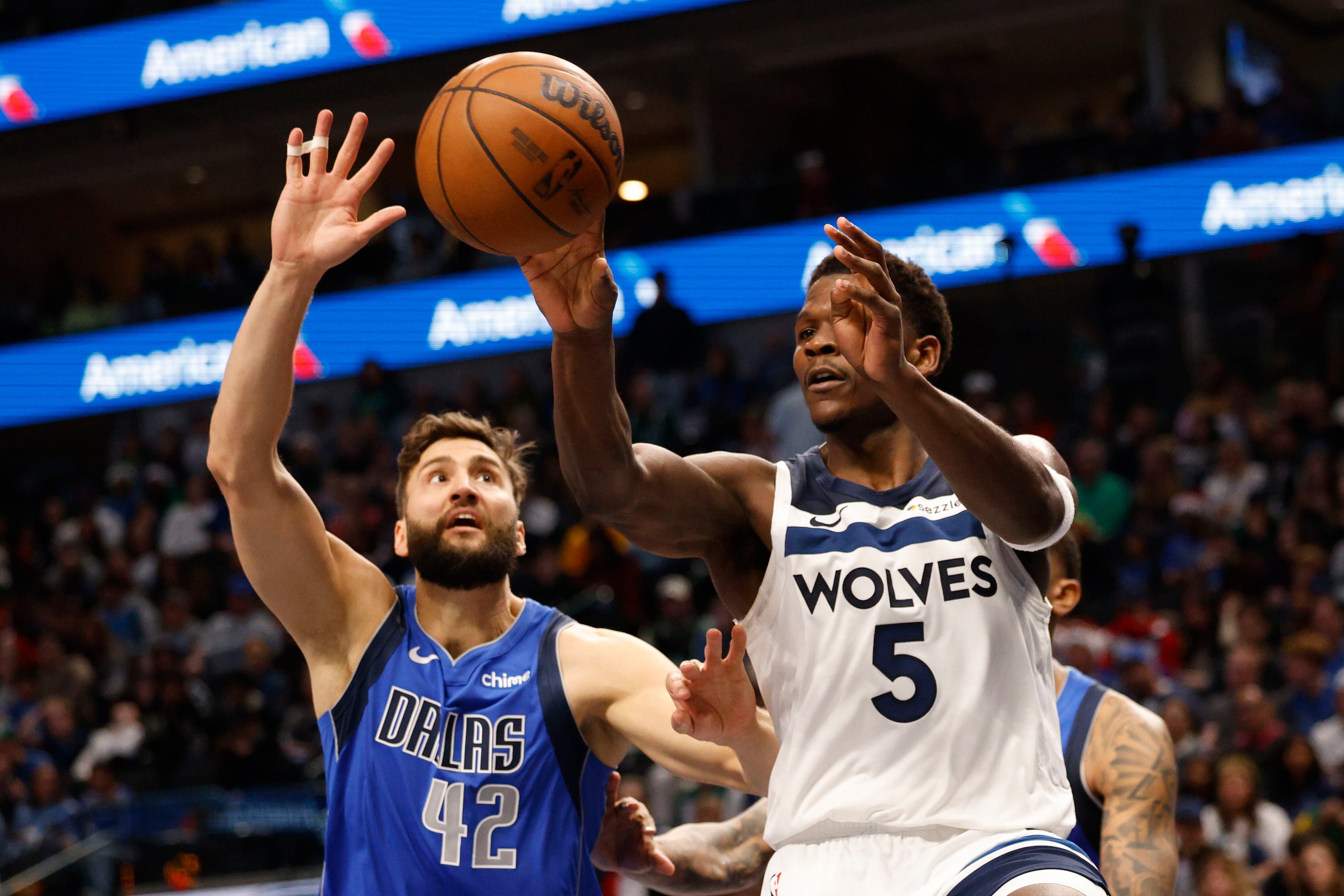 Minnesota Timberwolves guard Anthony Edwards (5) passes as Dallas Mavericks forward Maxi...