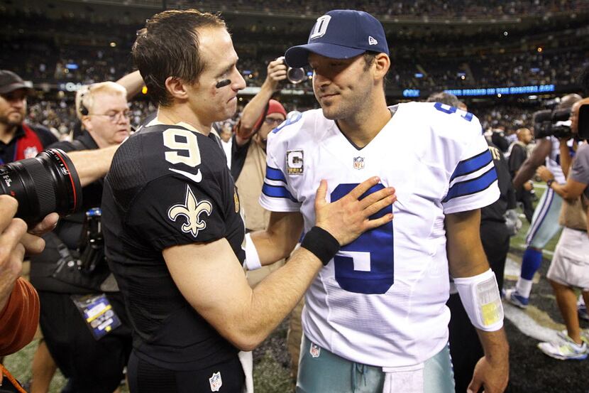 Dallas Cowboys quarterback Tony Romo (9) is consoled by New Orleans Saints quarterback Drew...
