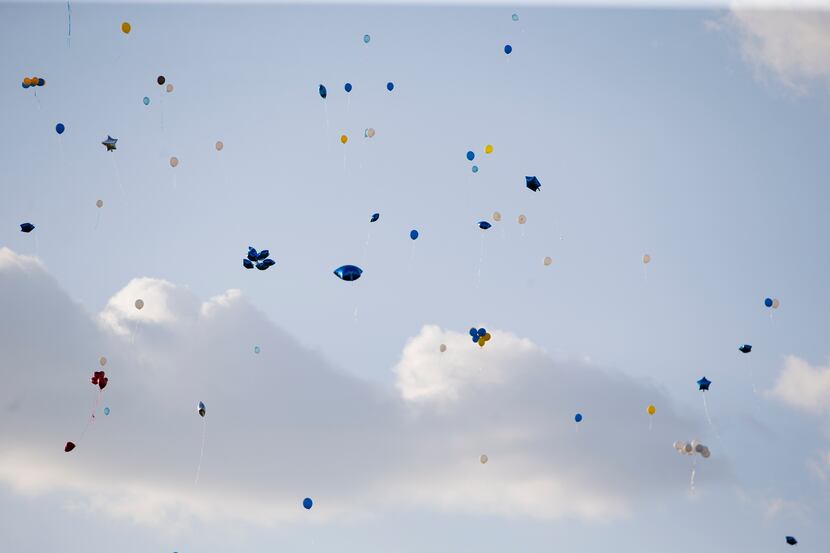 Colleagues, students and community members gathered to release balloons at a ceremony...