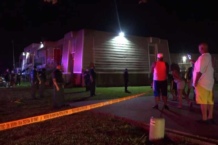 Dallas police and neighbors look things over after a man was shot and killed Thursday by a...