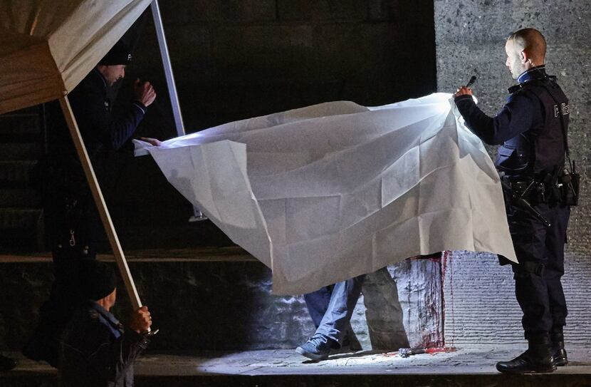 Swiss police officers hold a blanket to cover a dead body found near a Muslim prayer hall,...