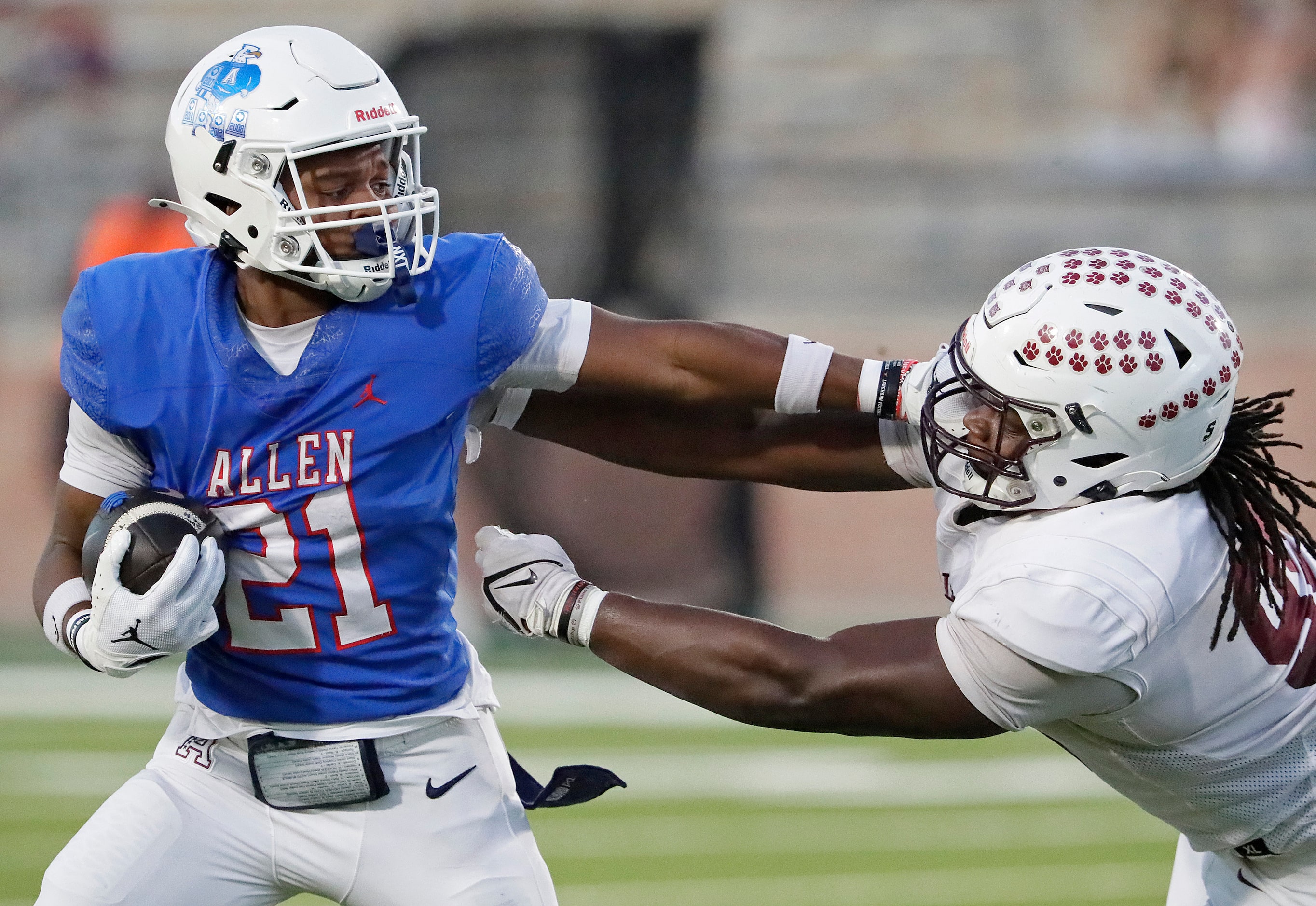 Allen High School running back Jaden Hambric (21) stiff arms Plano High School defensive...