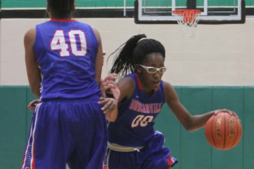 Duncanville guard Zarielle Green (00) dribbles around the block delivered by Duncanville...