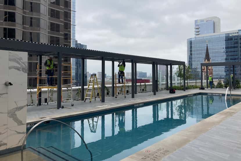 Workers put the finishing touches on a canopy on the pool deck of downtown Dallas' new JW...