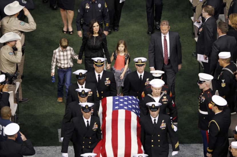 Taya Kyle and her children exit the stadium as the casket bearing her husband Chris Kyle's...