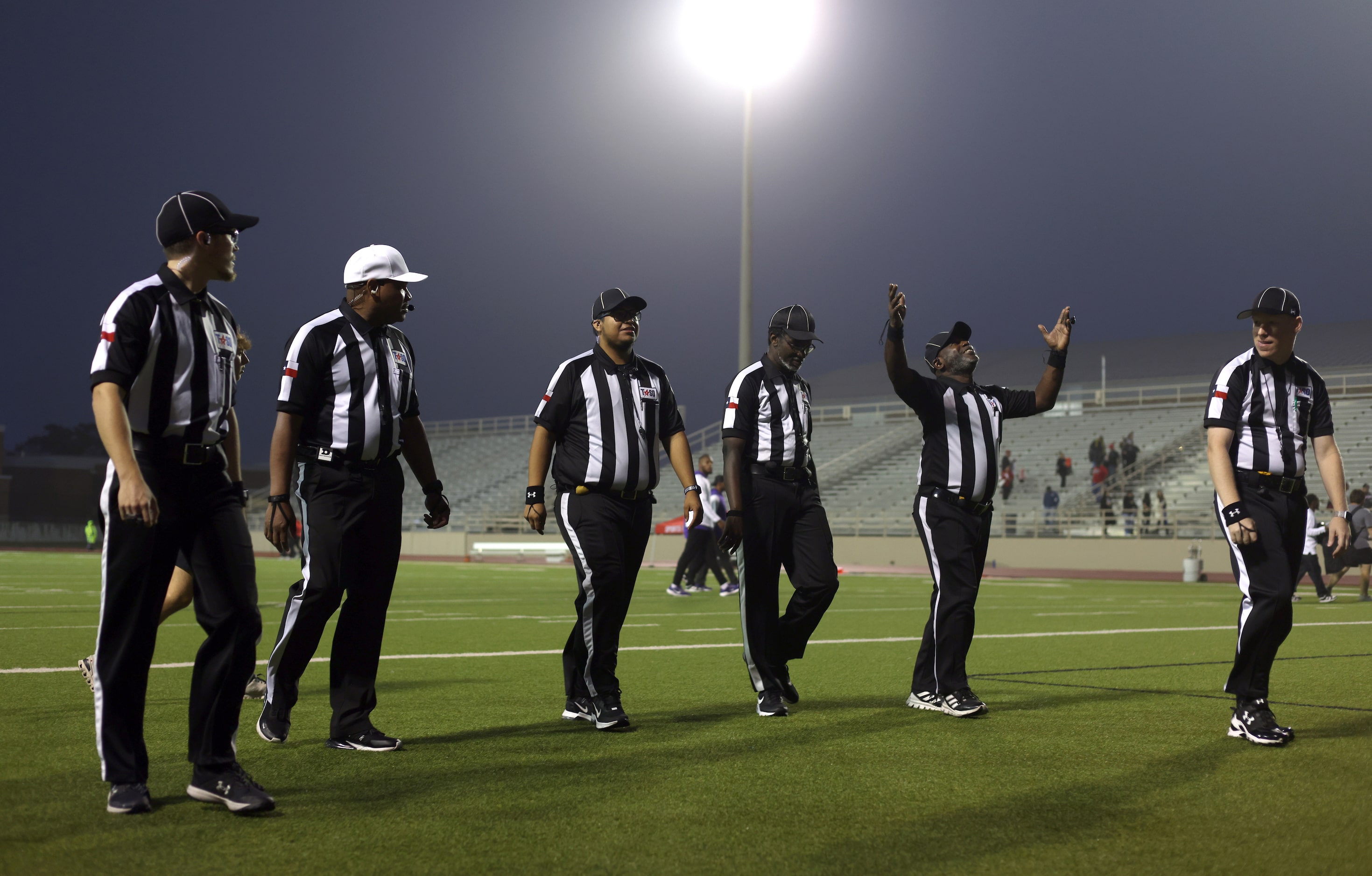 Game officials leave the field after clearing Richardson and Irving MacArthur football teams...