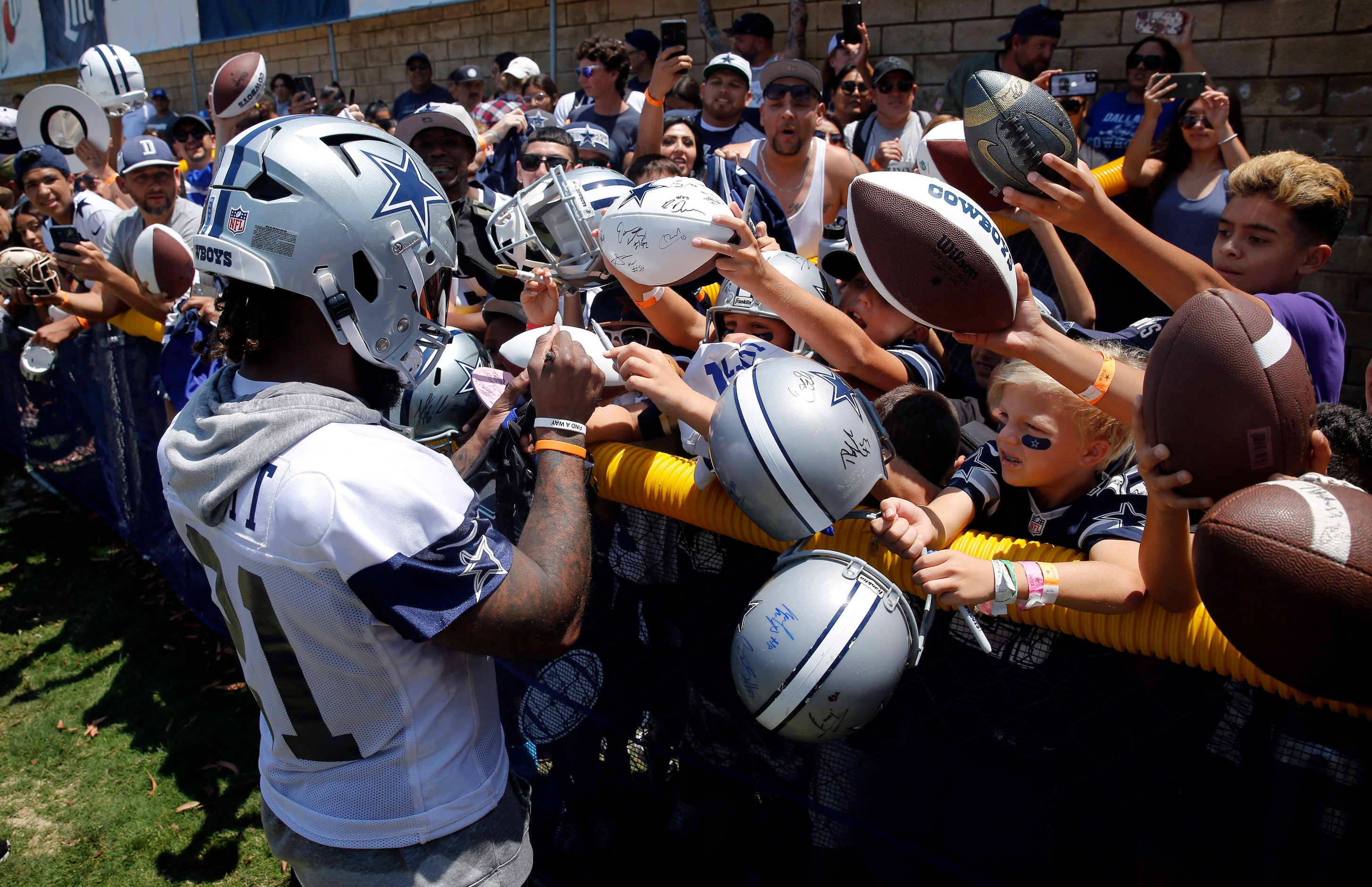 Dallas Cowboys running back Ezekiel Elliott (21) signs autographs for screaming kids...