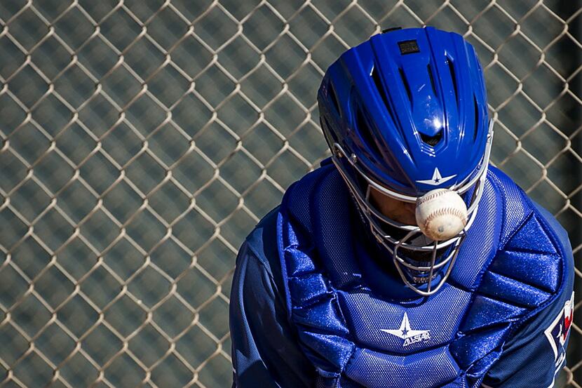 Texas Rangers minor league catcher Jose Trevino has a ball bounce off his mask during a...