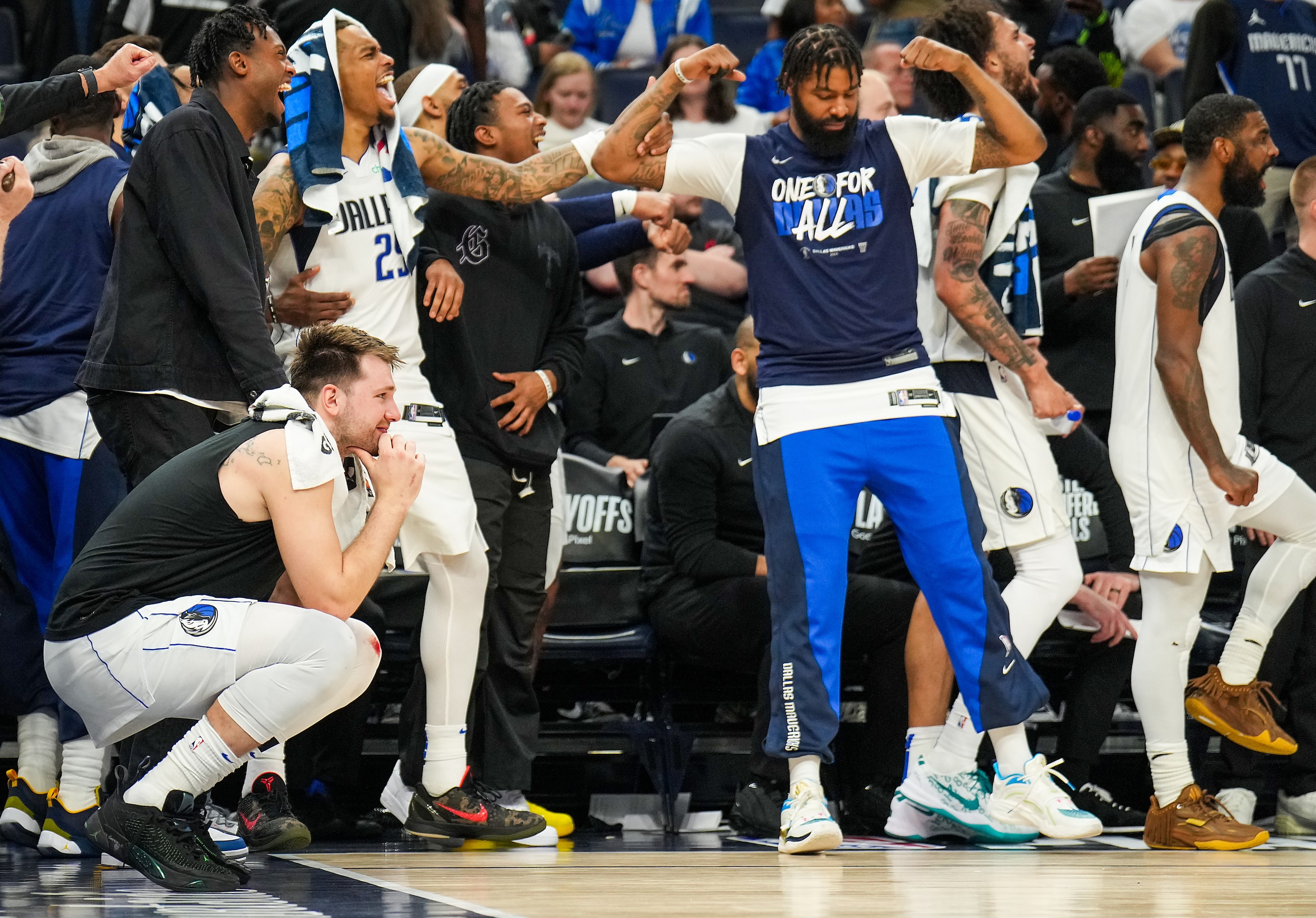 Dallas Mavericks players, including (from left) Luka Doncic (kneeling), P.J. Washington...