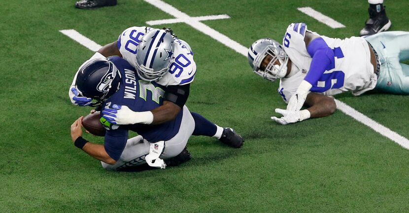 Dallas Cowboys defensive end Demarcus Lawrence (90) tackles Seattle Seahawks quarterback...