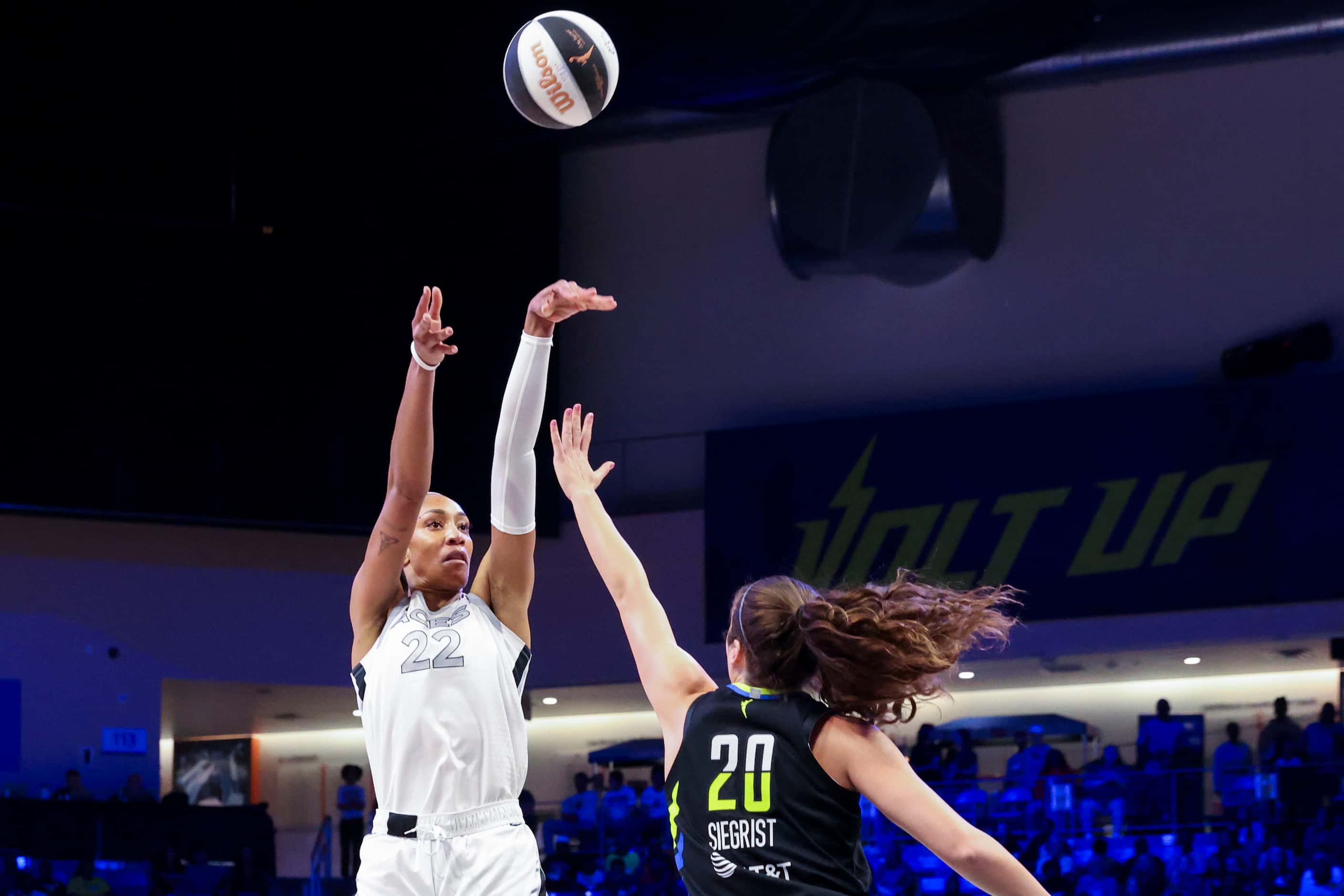 Las Vegas Aces center A'ja Wilson (left) shoots over Dallas Wings forward Maddy Siegrist...
