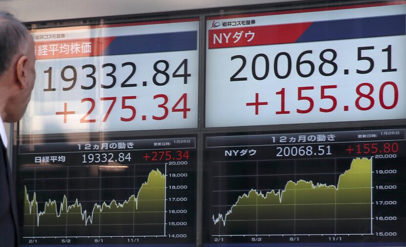 A man looks at an electronic stock indicator of a securities firm displaying Japan's Nikkei...