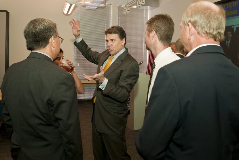 Governor Rick Perry, center, talks with attendees after presenting Emerging Technology Fund...