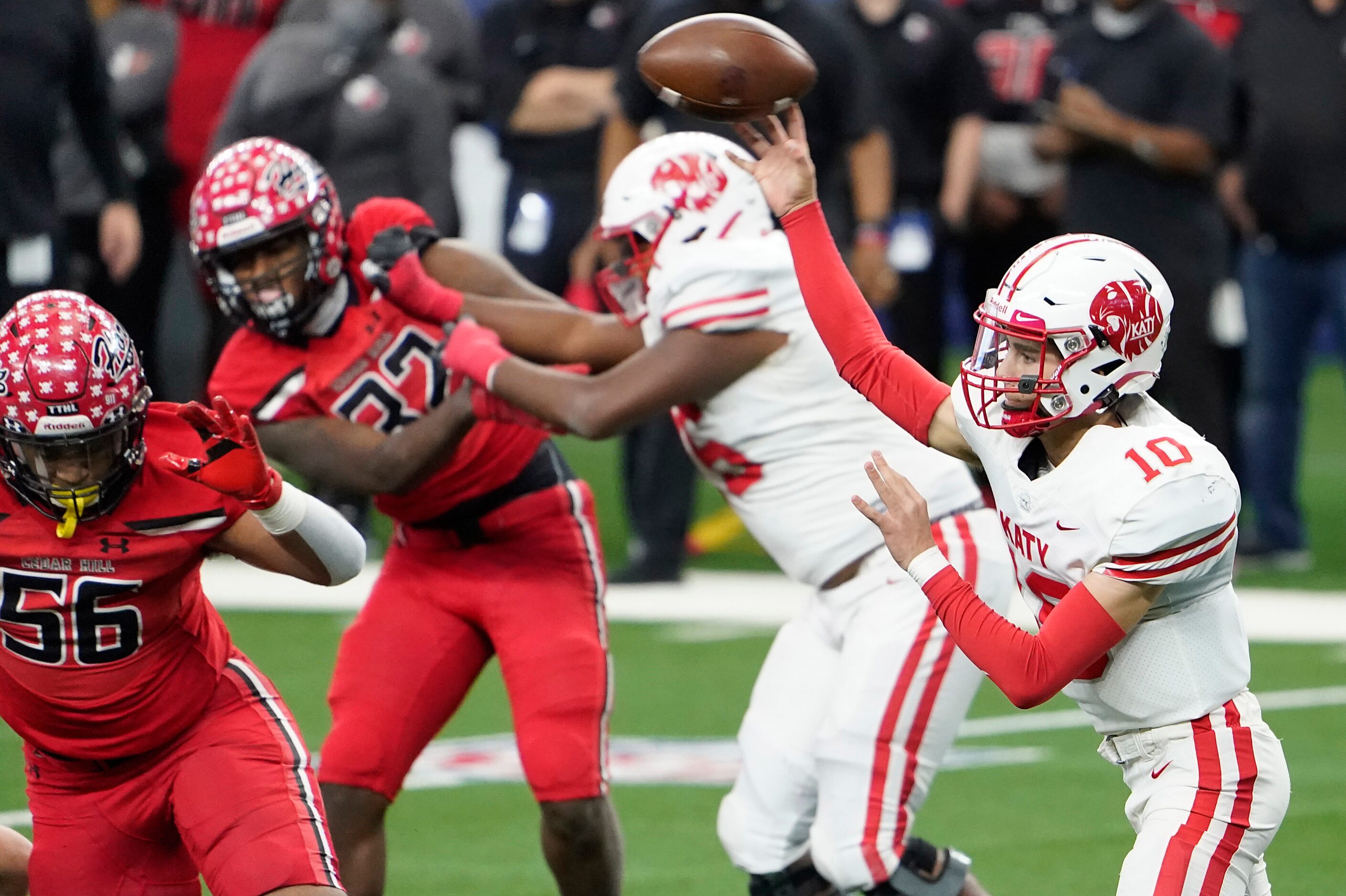 Katy quarterback Caleb Koger (10) throws a pass under pressure from Cedar Hill defensive end...