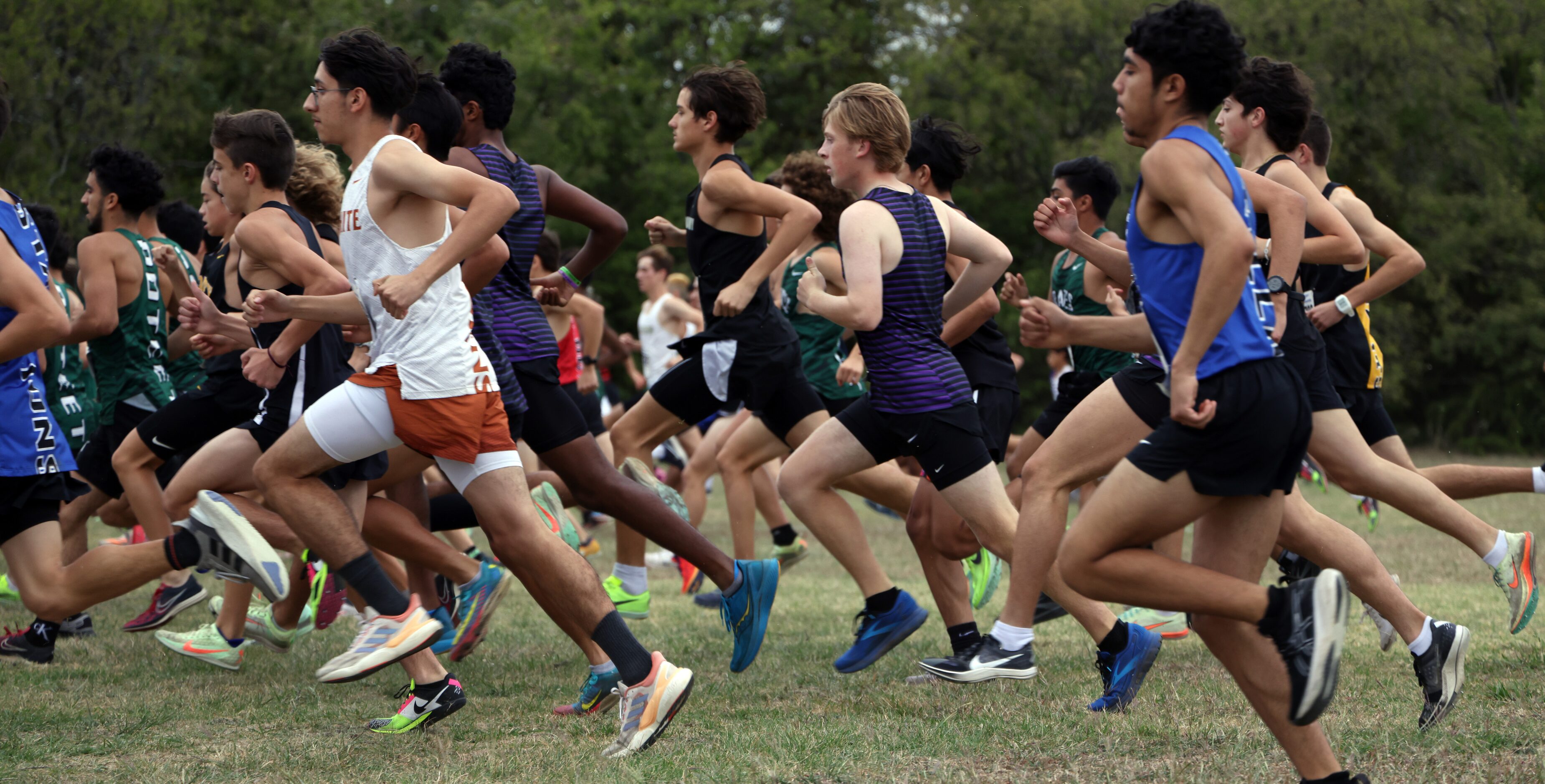 A flurry of runners bolt from the starting line in the Boys Class 5A Region 2 race. The...