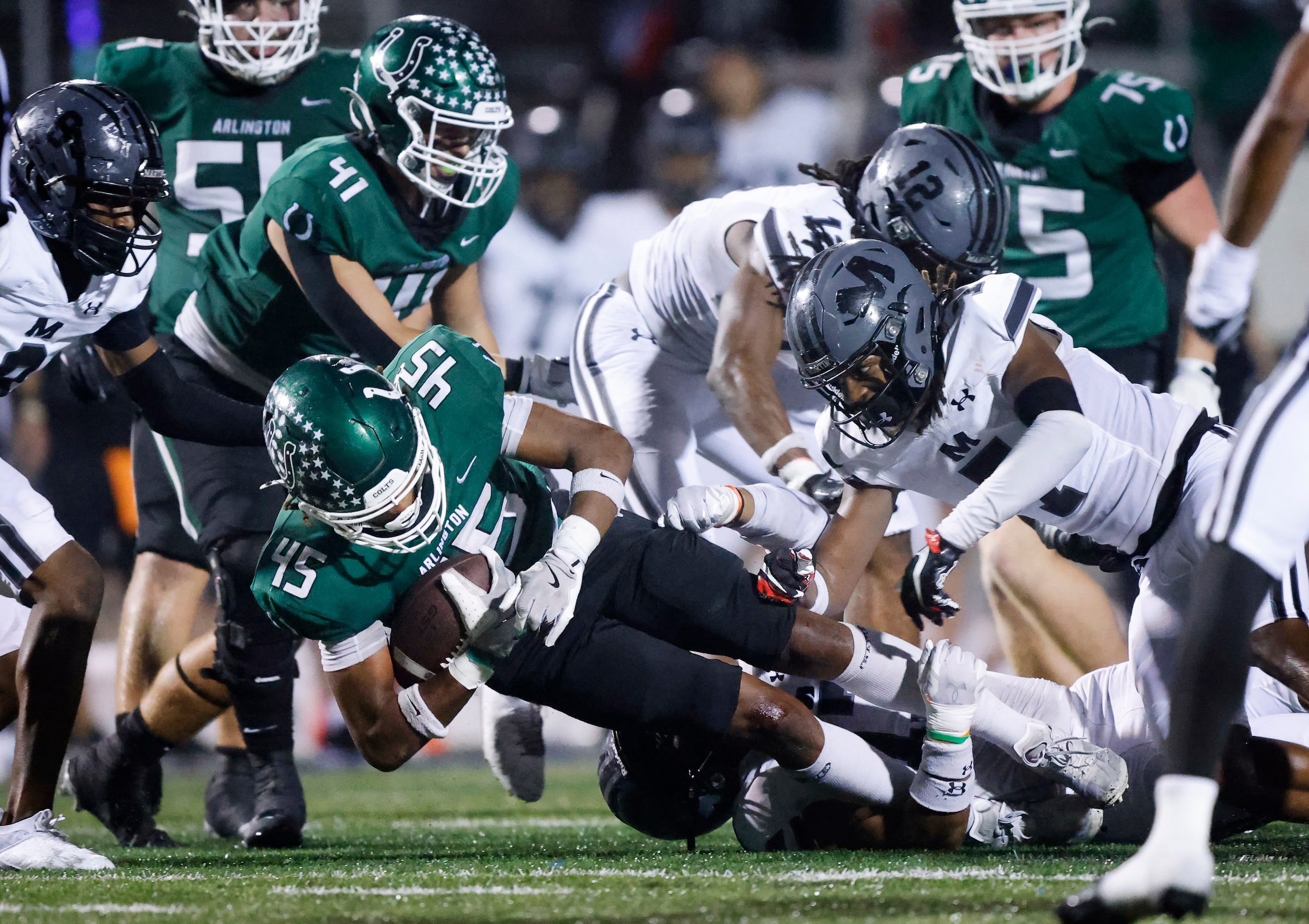 Arlington High wide receiver Isaiah Robertson (45) lunges ahead for additional yardage as...