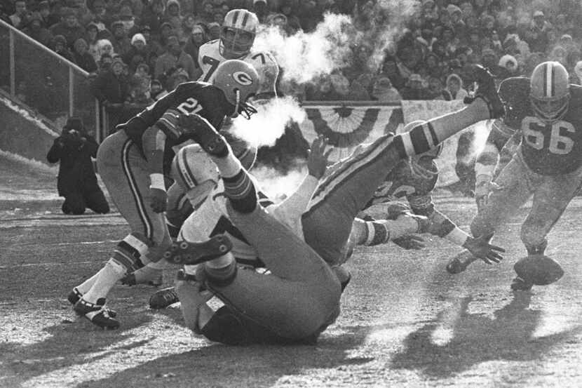 FILE - In this Dec. 31, 1967 file photo, players spill in all directions as a fumble occurs...