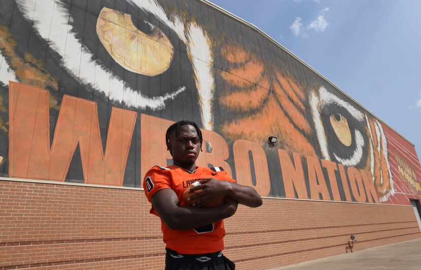 Lancaster senior receiver Ti' Erick Martin poses for a photo in front of a large painted...
