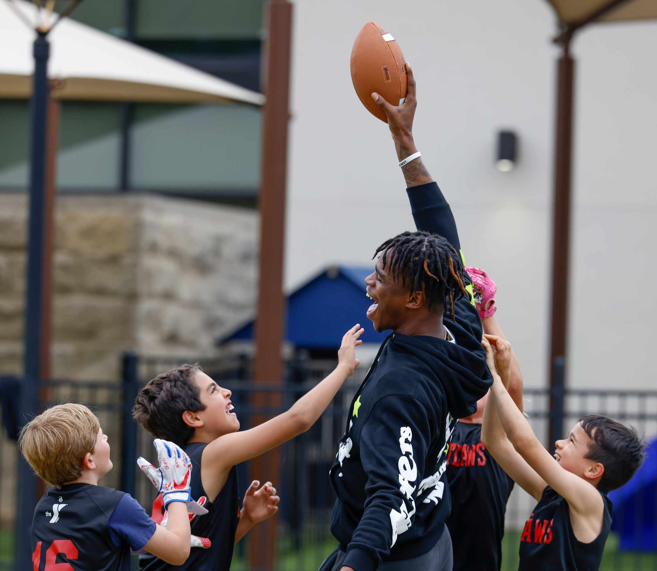 Surrounded by kids SMU’s Keyshawn Smith (center) cheers with the ball during a special...