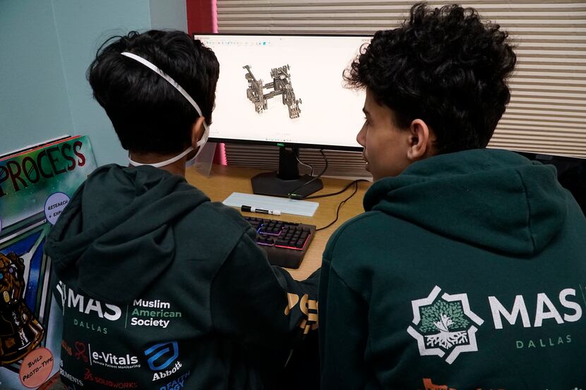 Marvels of MAS robotics team members Yusuf Hussain, 13, and Hazem Omar, 14, work on a...