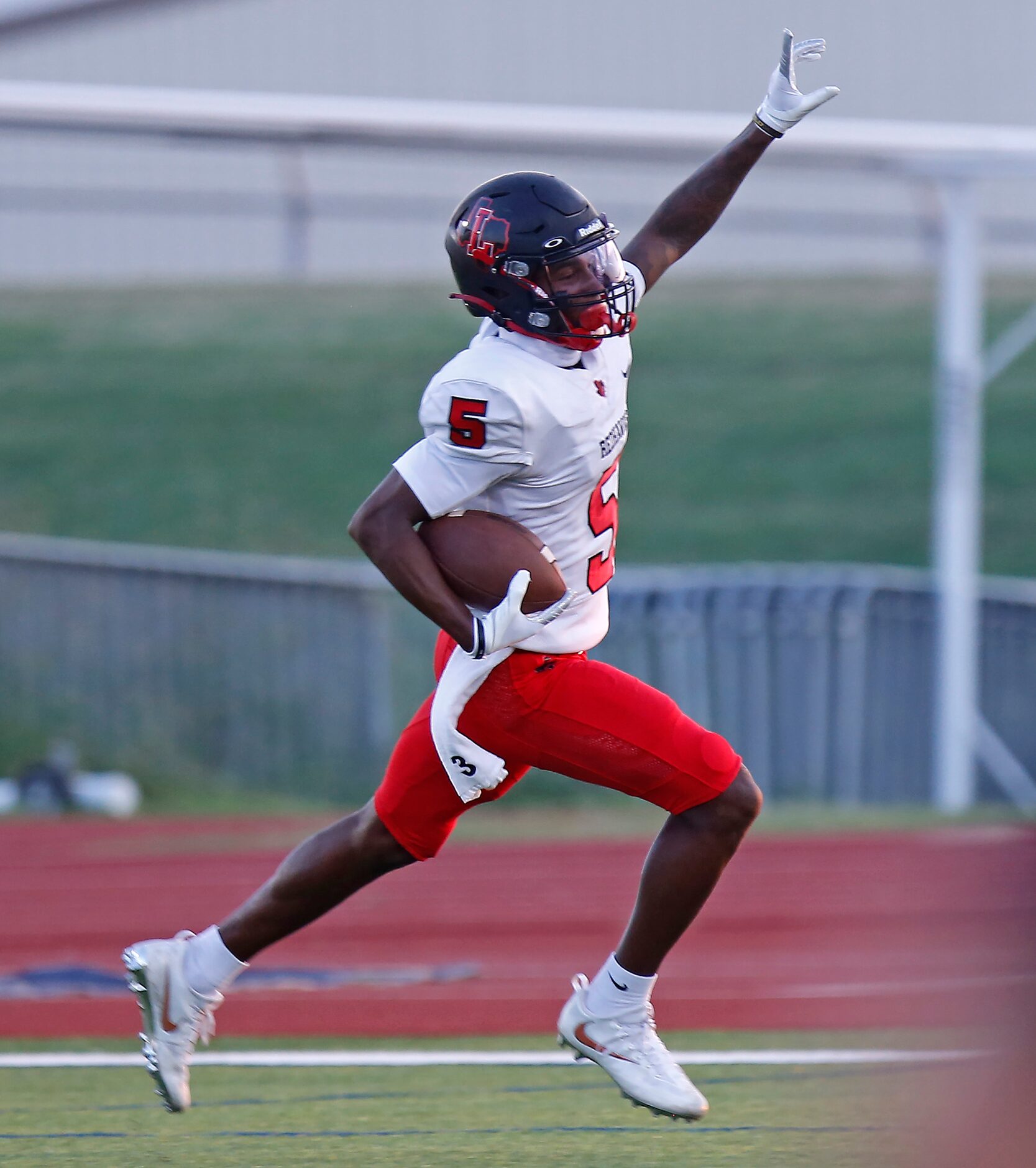 Liberty High School wide receiver Evan Stewart goes untouched into the end zone for a...