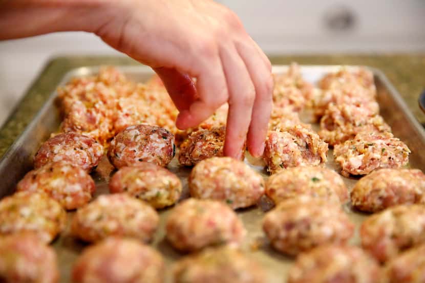 Restaurant owner and chef Julian Barsotti rolls rows of chicken thighs and pork belly...