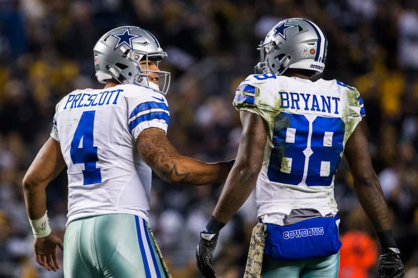 Dallas Cowboys quarterback Dak Prescott (4) talks to wide receiver Dez Bryant (88) after a...