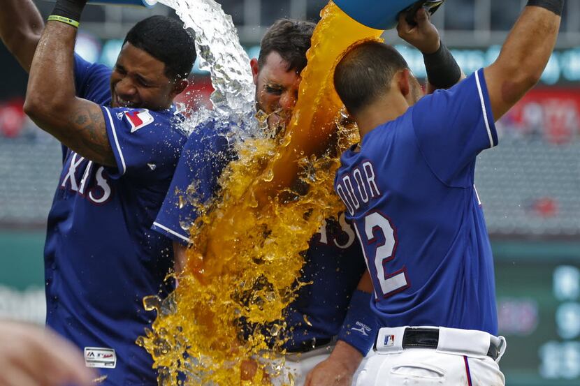 Texas Rangers catcher Bobby Wilson (6) has water and sports drink poured on him by shortstop...