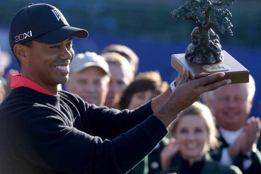 LA JOLLA, CA - JANUARY 28:  Tiger Woods holds the winner's trophy after his -14 under...