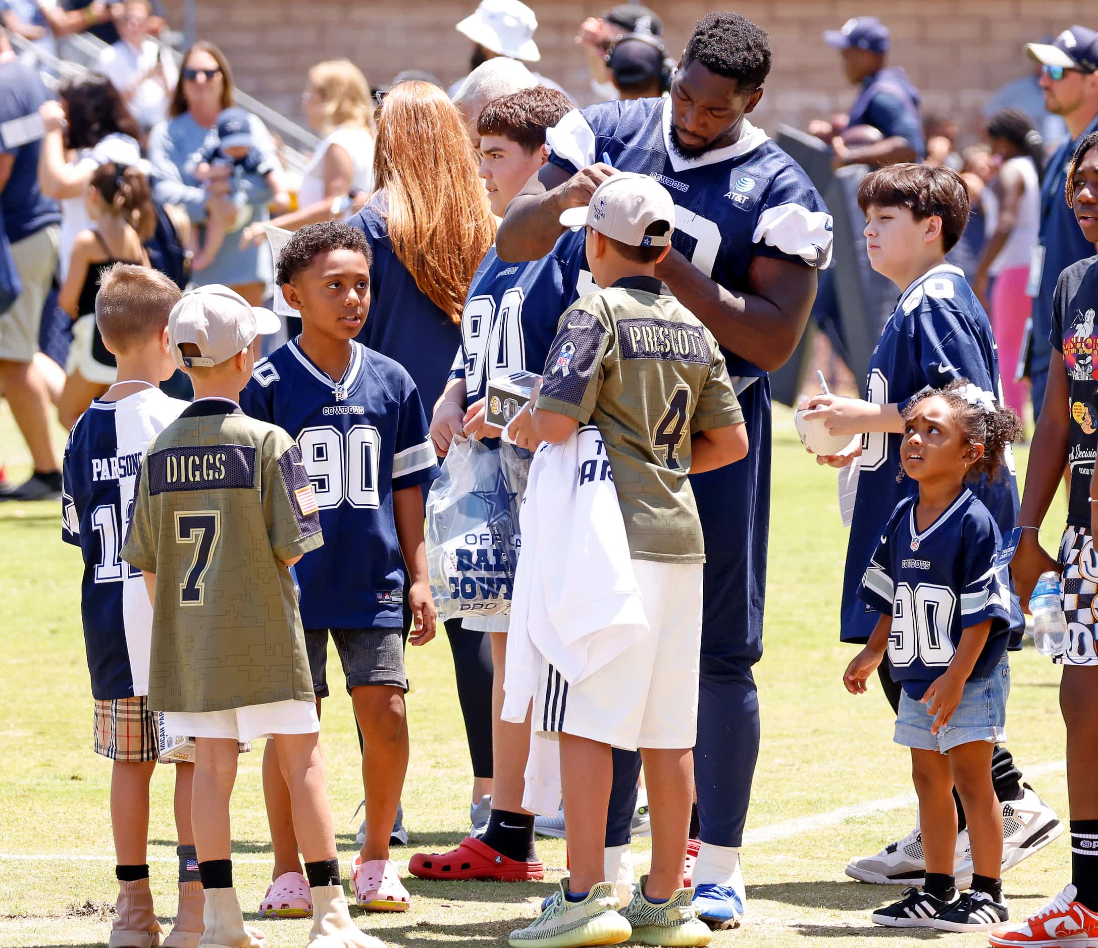Dallas Cowboys defensive end DeMarcus Lawrence (90) signs autographs for kids following...