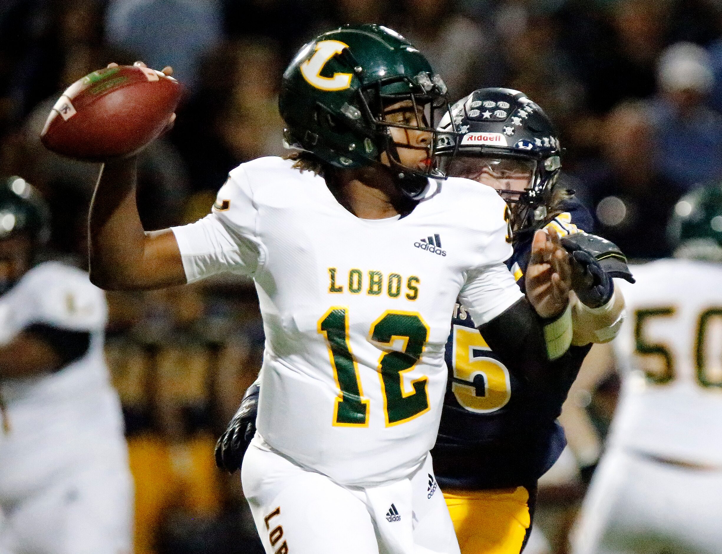 Longview High School quarterback Jordan Allen (12) throws a pass on the run with pressure...