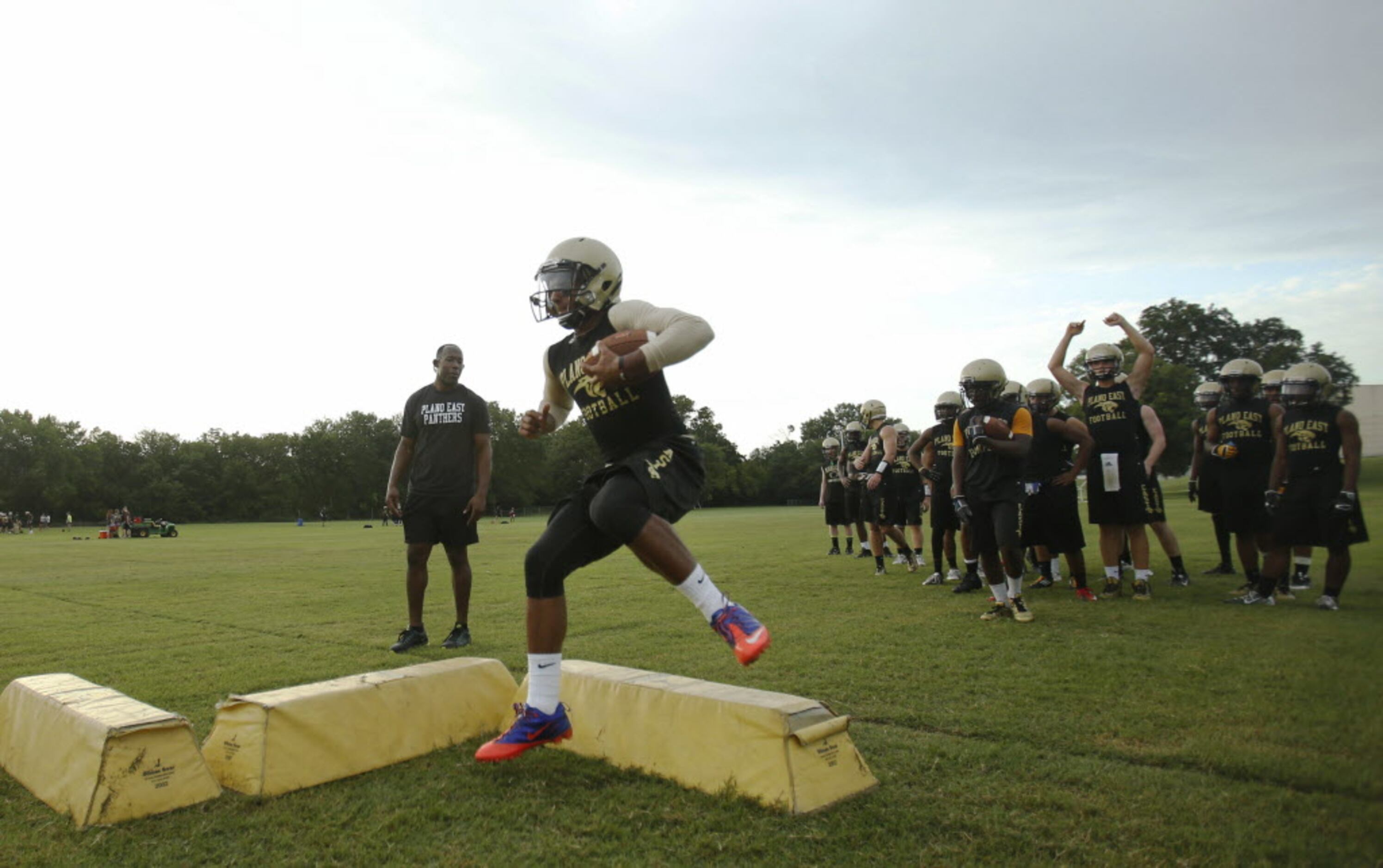Plano East's quarterback Miles Thompson runs through a drill during the first day of...